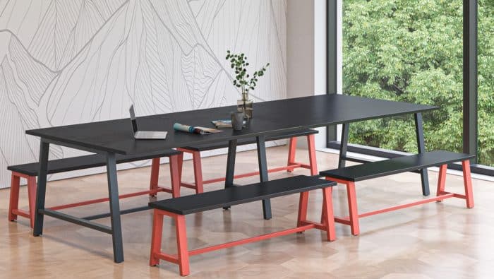 Aspect Tables - dining height A frame table with 1200mm top in Anthracite and Salmon Pink finish shown in a breakout space