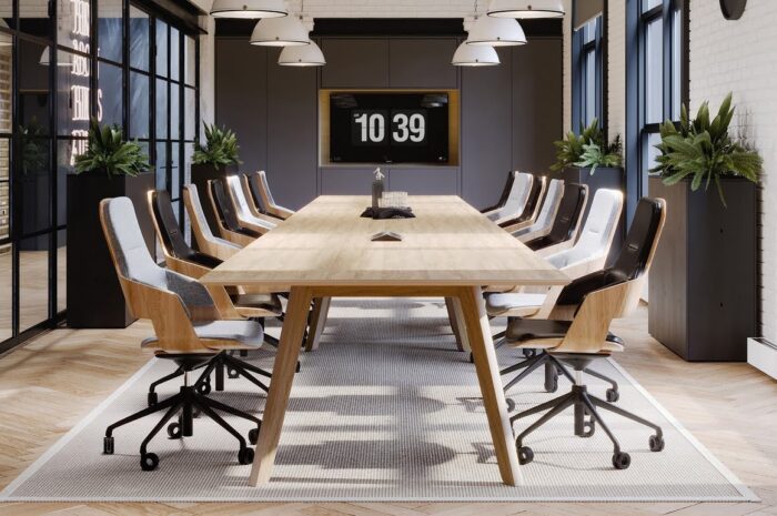 Assemble Executive Chairs group of mid back chairs with natural oak shells and black bases around a table in a meeeting room