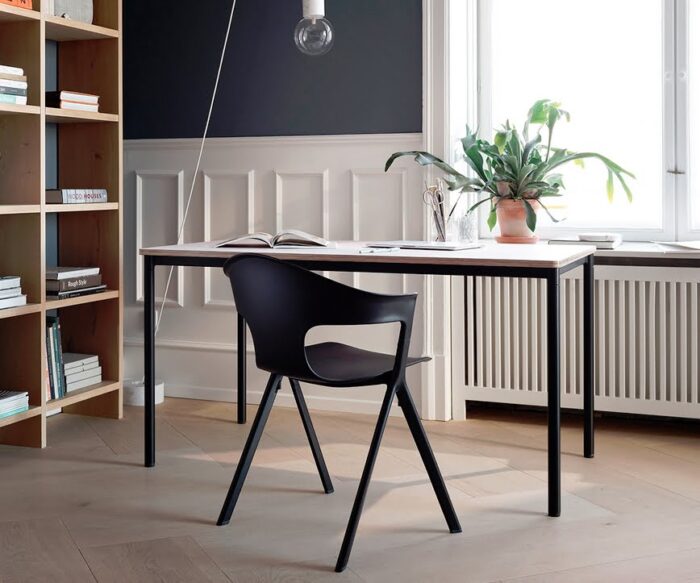 Axyl Chair & Stool single armchair in black shown in front of a desk