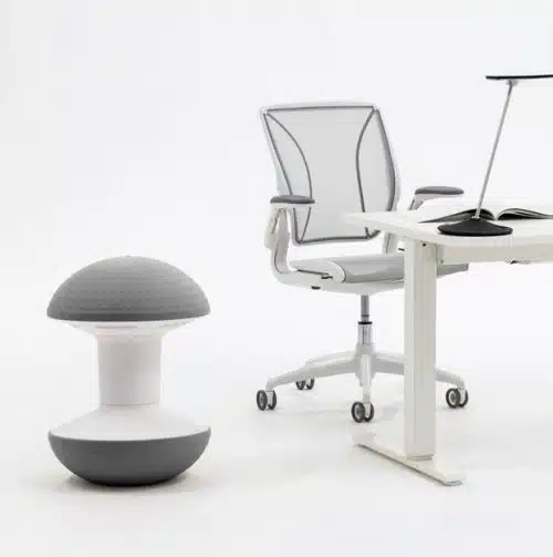 Ballo Stool shown with grey dome and white body, by a desk
