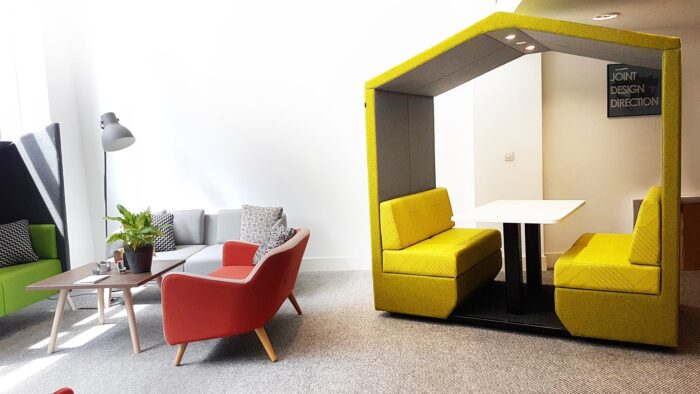 Bea Meeting Den 4 seater booth in yellow upholstery with table and lighting shown with sofas in a breakout area