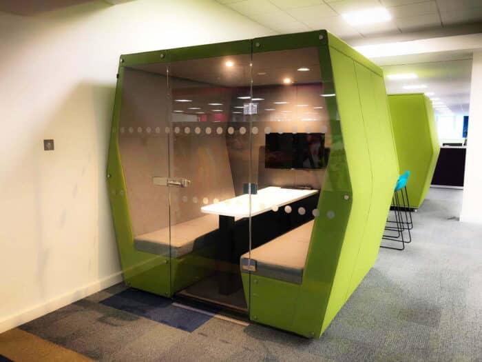 Bill Meeting Den 6 seater booth with glass door, upholstered end wall, table and mounted screen