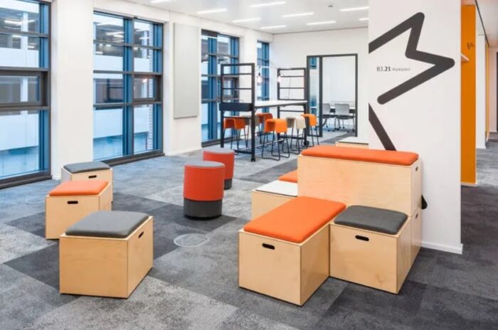 Bleachers Modular Seating single bases, double double height bases with seat pads shown in a breakout area alongside a poseur table and high chairs