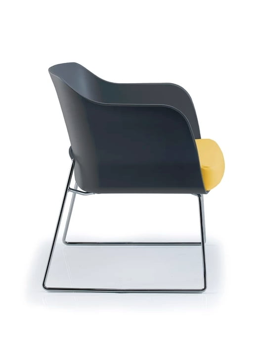 Bloom Visitor Chair side view of chair with a black polypropylene shell, upholstered seat pad in yellow and a chrome sled frame