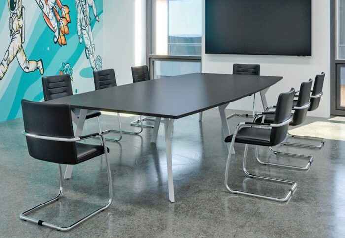 Boardroom Tables with a black boat shaped top and a white Y leg frame shown in a meeting room
