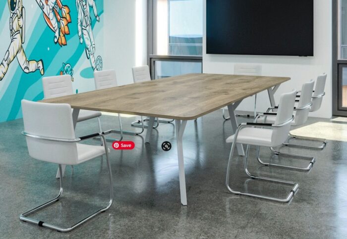 Boardroom Tables with a wood effect shaped rectangular top and a white Y leg frame shown in a meeting room