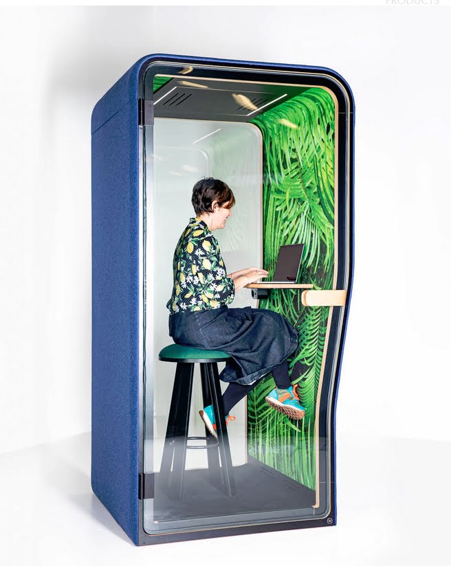 BuzziNest Phone Booth with felt printed interior upholstery, shelf and power module shown with user inside the booth and seated on a stool