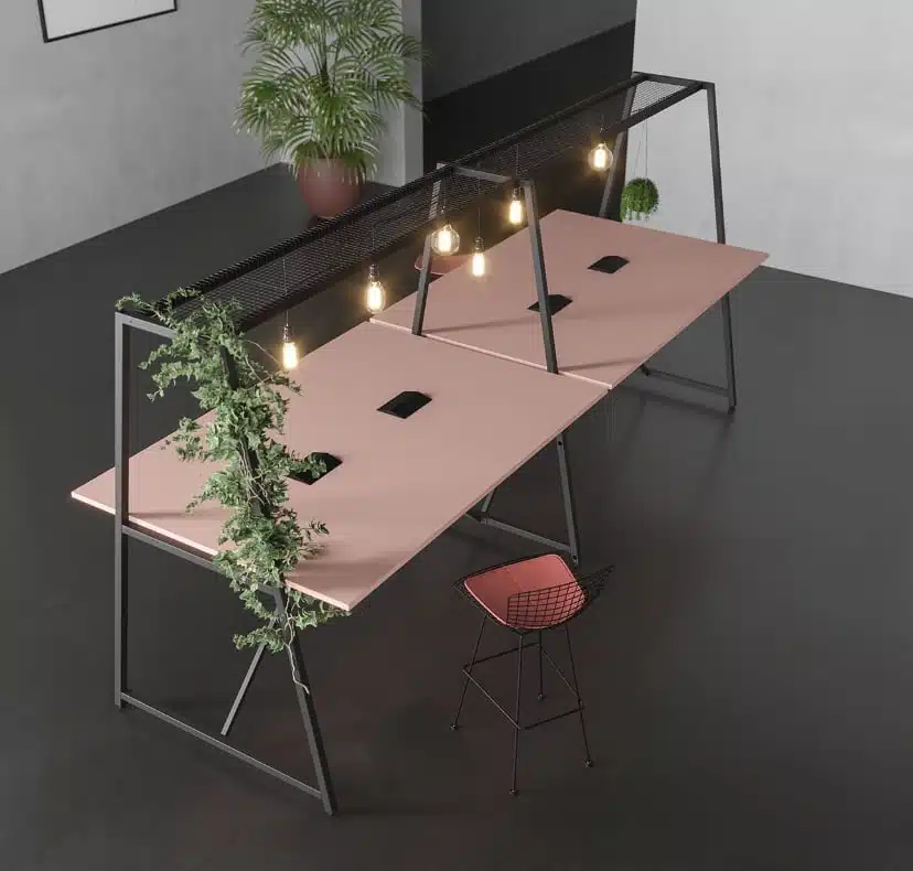 Canopy Table poseur heigth with a pink desk top and black metal frame, shown with pendant lighting and though desk power modules