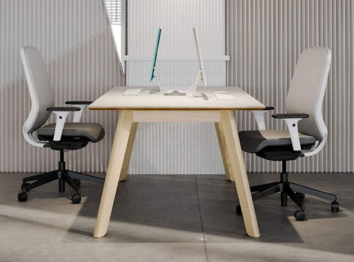 Centro Breakout Tables in natural oak, used as a desk, with laptops and two task chairs facing each other
