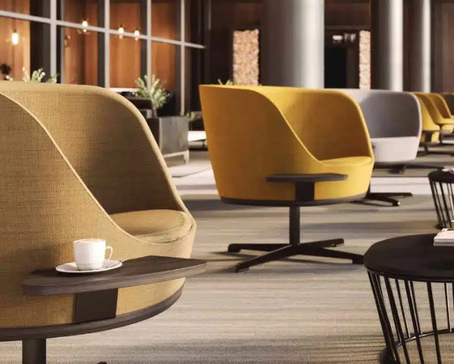 Dixi Chair group of low back tub chairs shown in a breakout area with dixi cage base coffee tables