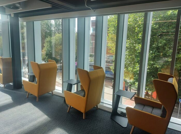 Douglas Soft Seating high back wing chairs in a row by the window shown with laptop tables