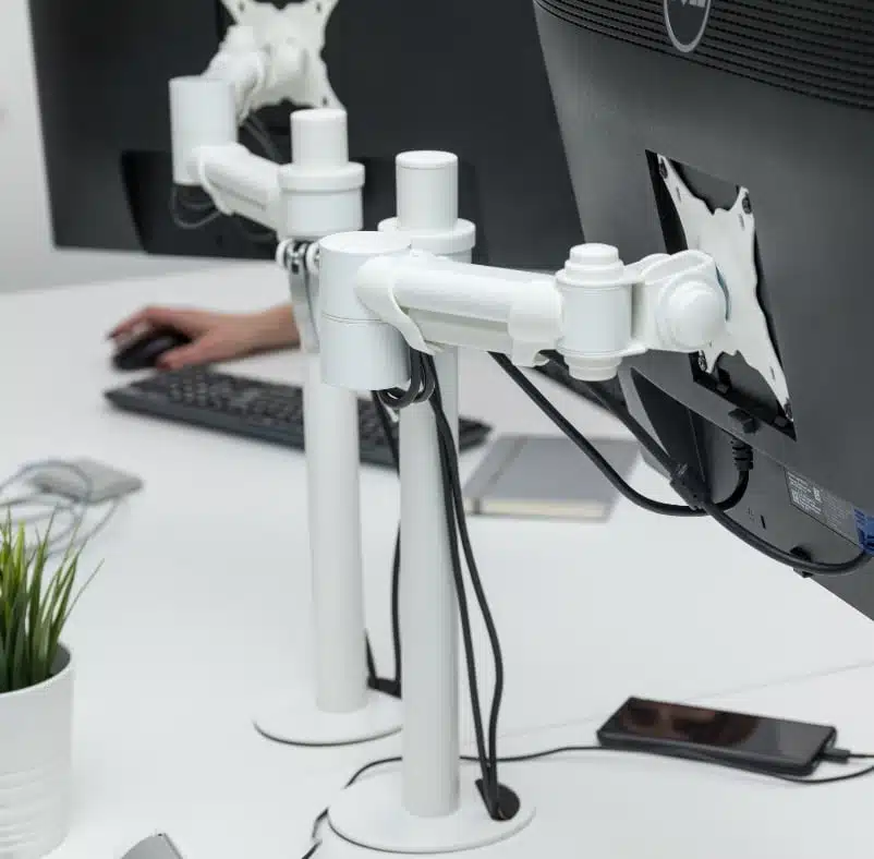 FSA1 Monitor Arm two arms in white shown mounted on a desk with attached screens