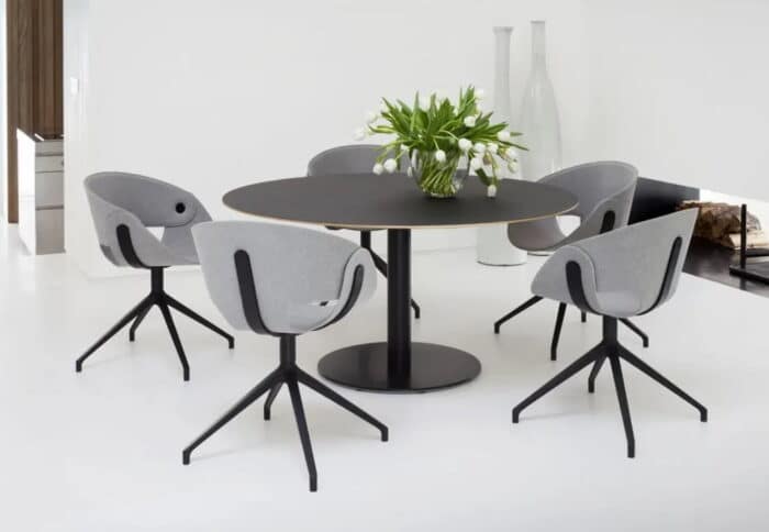 Flat Chair shown with black raised 4 star swivel bases around a meeting table in a work space