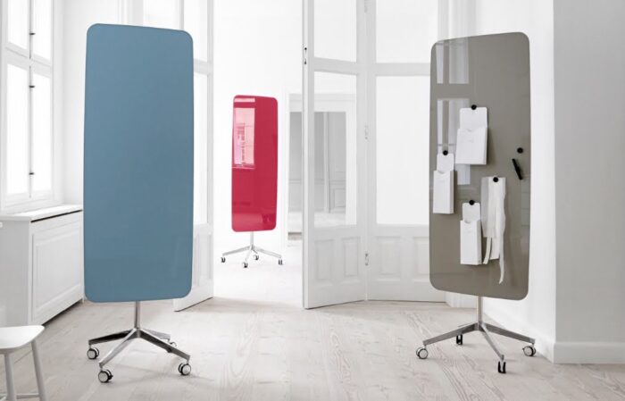 Flow Mobile Writing Board three writing boards with soft curved edges in various colours with polished aluminium bases on castors, shown in a workspace