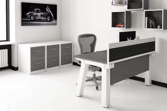 Force Bench Desk single sided desk with white frame, grey top, grey modesty panel and desk screen in an office