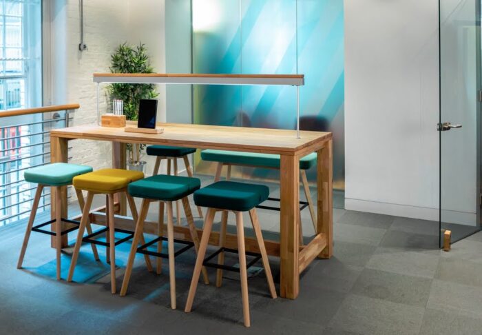 GD10 Poseur Tables 4 leg table shown with LED light bar and high stools in an office space