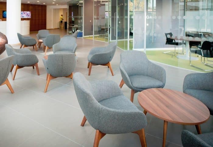 Ilk Soft Seating - low back chairs with 4 leg wooden frame bases shown with tables in a breakout space