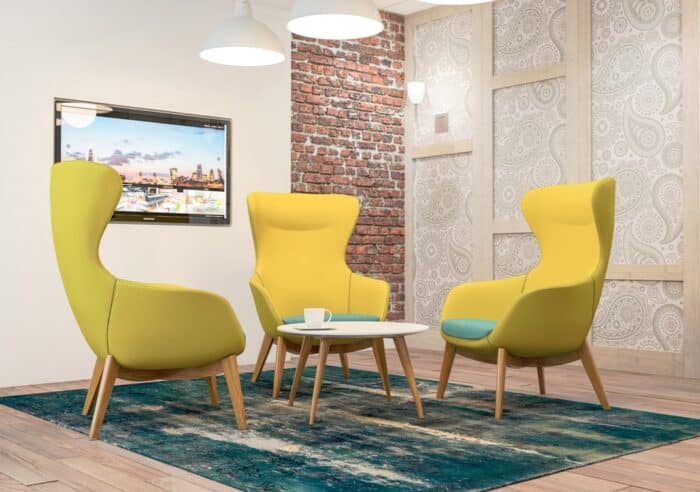 Ilk Soft Seating three high back chairs with 4 leg wood frames shown with a coffee table in a breakout space