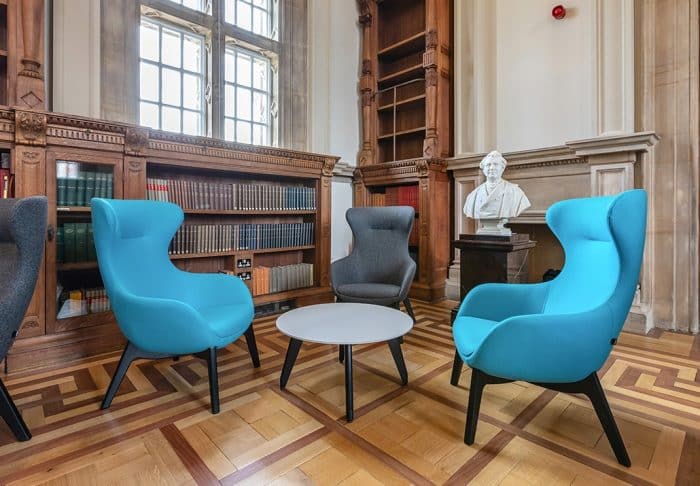 Ilk Soft Seating - three high back chairs with black 4 leg wooden frame bases shown in a library