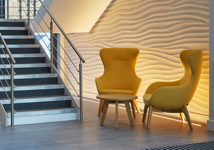 Ilk Soft Seating two high back 4 leg chairs shown in a corridor