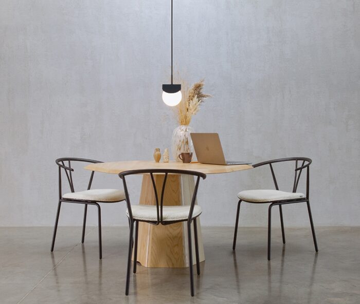 Isle Table with one base and 1200mm circular top with a waterfall edge shown with an overhead pendant light and three chairs