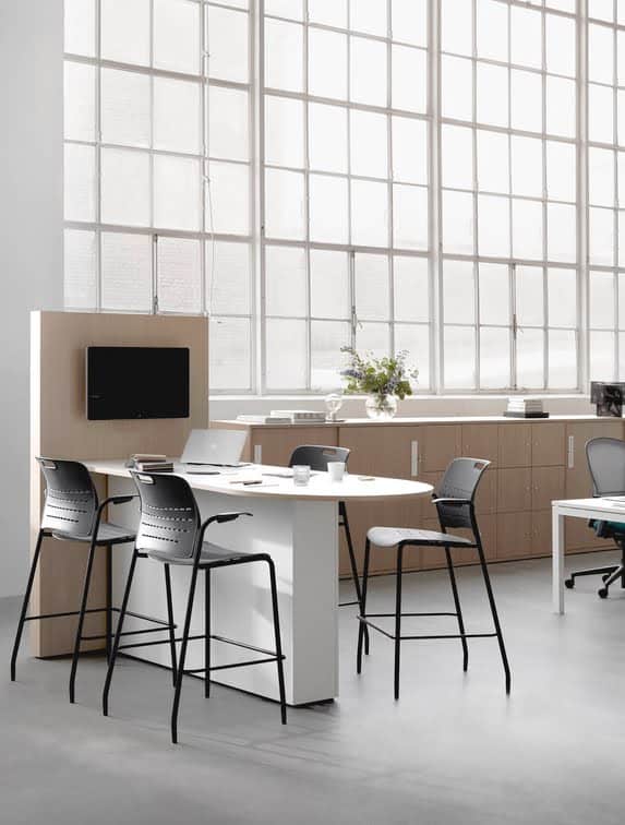 Jonny Chair 4 high stools with arms shown around a media unit in an office space