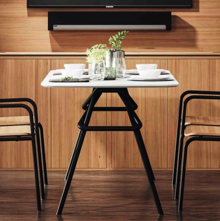 Konya Table rectangular dining height table with a black frame and white chamfered edge top shown with 4 Konya chairs in a meeting space