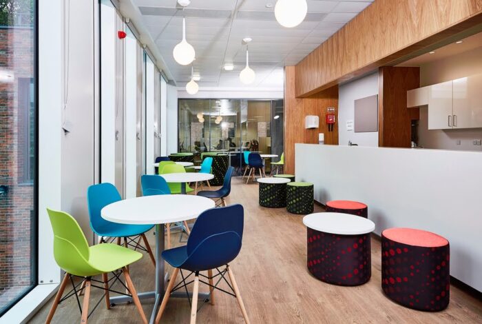 LG4 Wood Seating groups of chairs shown around circular diner height tables and pouffes in a breakout space