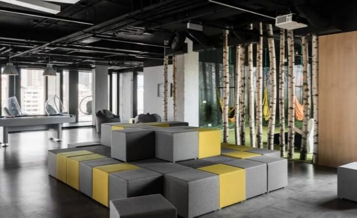 Ligo Modular Seating And Tables pouffes in grey and yellow upholstery in a two tier square configuration