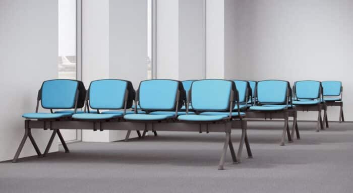 Mia Beam Seating four 4 person fully upholstered units in blue fabric shown back to back in a meeting room