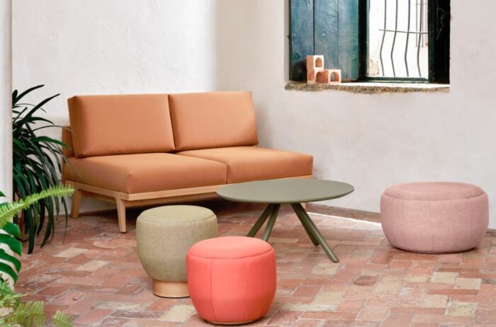 Pausa Modular Seating two seater sofa with no arms and wooden trim, shown in a breakout space with a table and round pouf