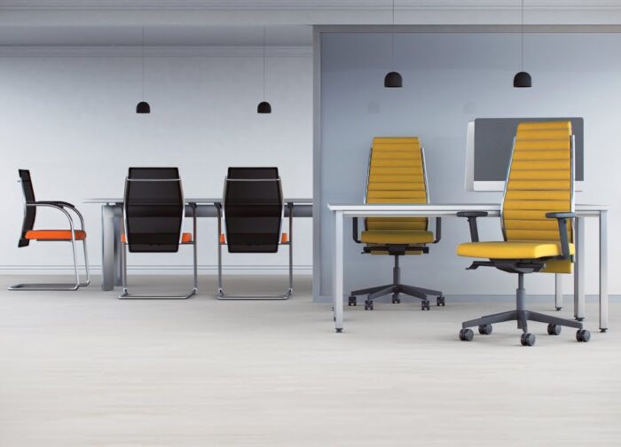 Plan Executive Chair with high ribbed backs, yellow upholstery and black bases shown by a desk near three mesh back chrome cantilever chairs