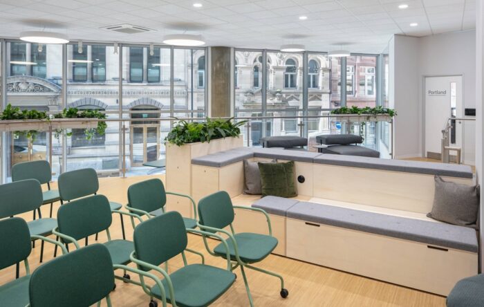 Platforms Modular Seating straight configuration shown with cushions and planter units by rows of chairs in an office meeting space