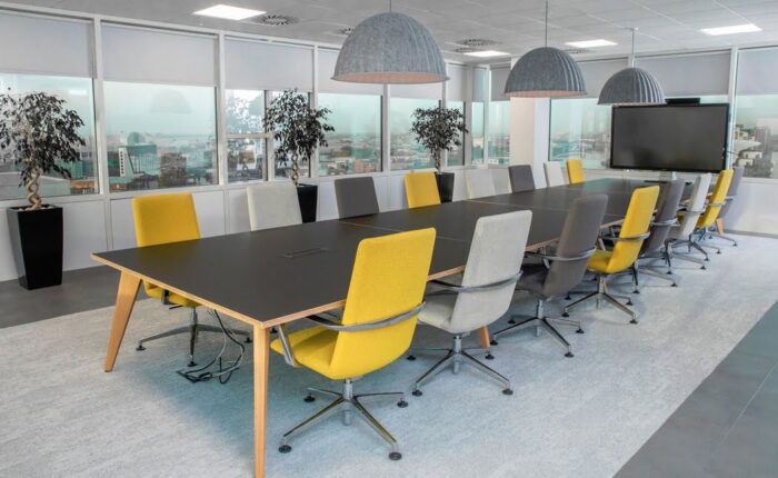 Pyramid Conference Tables with wood frame shown with 14 high back chairs in a conference room
