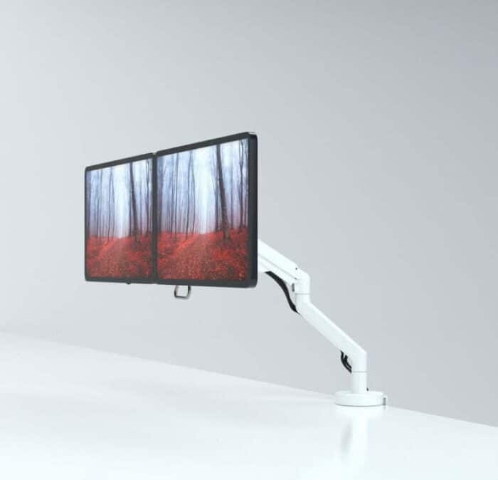 Reach Plus Monitor Arm shown with two screens mounted on a desk edge