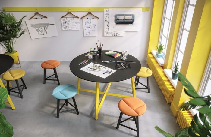 Relic Breakout Table circular low tables with black top and yellow frame shown with low stools in an office work space