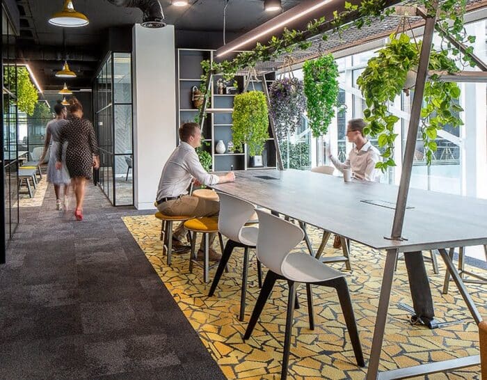 Relic Cloud Collaboration Table in an office space with stools , chairs and hanging greenery