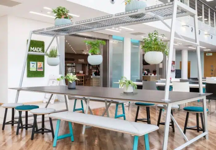 Relic Cloud Collaboration Table shown in a cafe environment with stools and bench seating