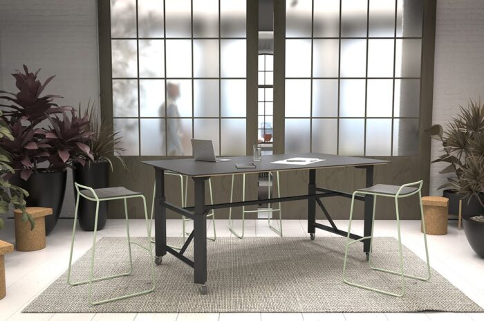 Relic Project Table rectangular height adjustable table on castors shown with a black top and frame and Veck stools in a workspace