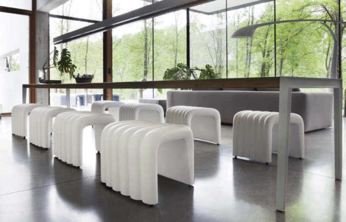 River Snake Breakout Seating 8 white stools shown around a bench table in a work place