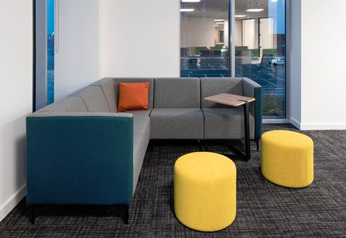 Huddle Modular Low Back Seating corner configuration shown with a laptop table and two pouffes in a work space