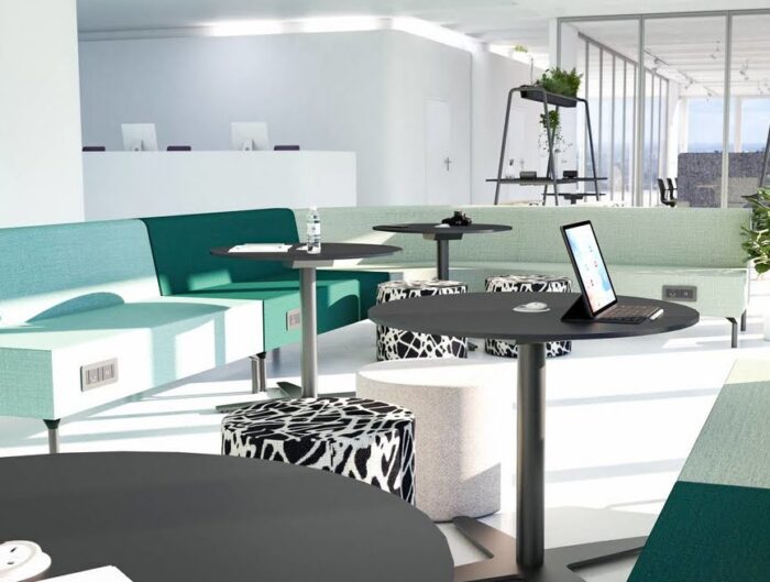 Skyline Seating group of units with integrated power modules shown with round tables and upholstered pouffes
