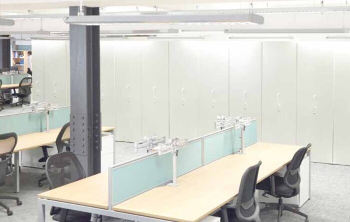 Smart Wall Storage shown against a wall in an office space with bench desking and task chairs