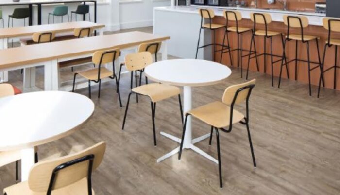 Solo Breakout Chair And Stool group of chairs abd stools with oak seats and backs and black frames shown in a canteen space