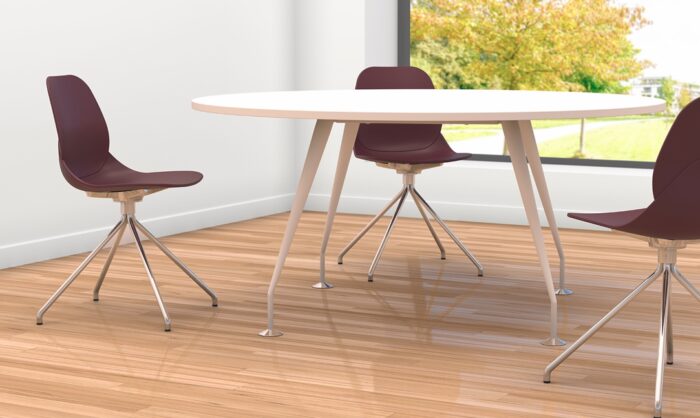 Spire Tables shown with round top and legs in white, shown in an office space with meeting chairs