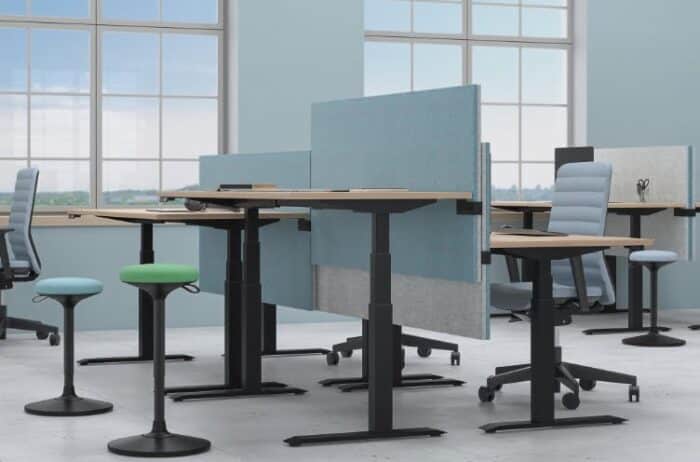 Sway Pivoting Stool shown near a group of sit stand desks