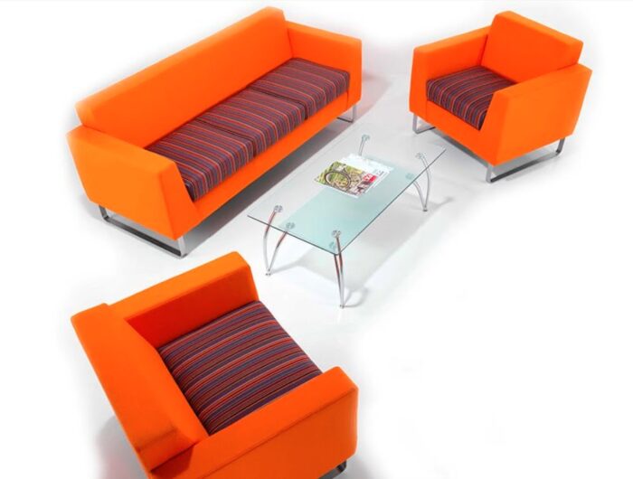 Synergy Solo Soft Seating a three seat sofa and two armchairs with two tone upholstery and silver sled frames shown with a glass top coffee table