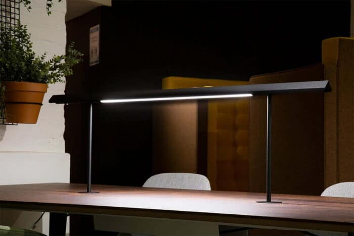 Frovi Task Light shown installed on a table with mahogany top