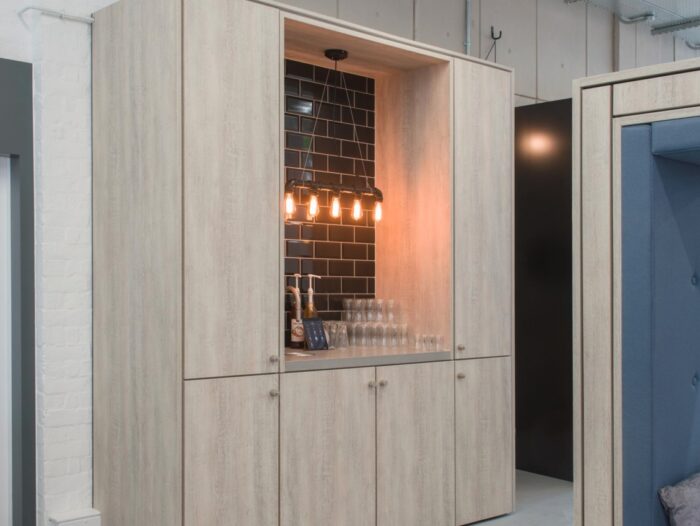 Teapoint unit shown with a smart tap, lighting and glassware with tall cupboards on either side