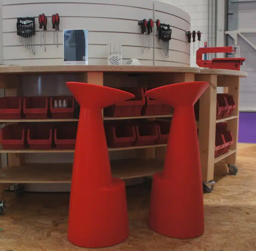 Voi Stool two stools in red shown in a workshop